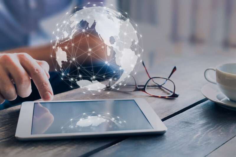 Global business network connection around digital globe, internet of things (IoT) concept, international communication, worldwide finance technology (fintech), businessman using digital tablet